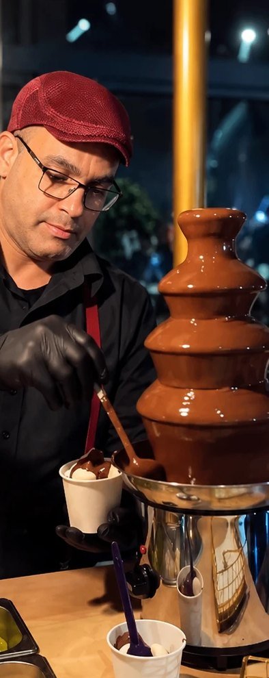 Atendente servindo na estação de fondue de chocolate